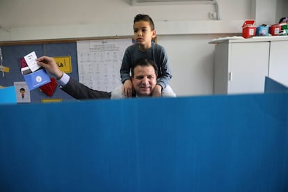 Los israelíes elegirán sus representantes en una Cámara de 120 escaños, para cuyo acceso los partidos tienen que superar el 3,25 % de los votos emitidos. En la imagen, un votante junto a su hijo en un colegio electoral en Haifa.