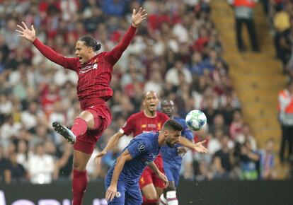 El jugador del Liverpool, Virgil van Dijk, salta para rematar el balón ante la presión del jugador del Chelsea, Olivier Giroud.