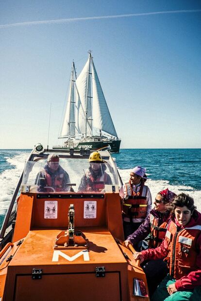 Varios miembros de la tripulación del Rainbow Warrior III a bordo de una de las lanchas rápidas que utiliza Greenpeace para sus acciones en alta mar. Al fondo, el velero de la organización ecologista, fotografiado el pasado abril en el canal de la Mancha.