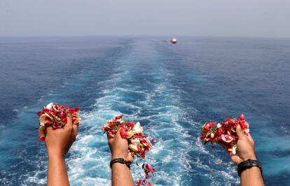 Varias personas lanzan flores al mar en homenaje a las víctimas, el 6 de noviembre de 2018.