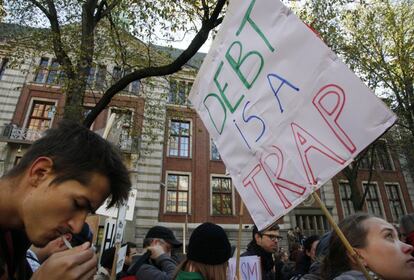 Decenas de indigandos holandeses sostienen pancanrtas a las afueras de la bolsa holandesa.