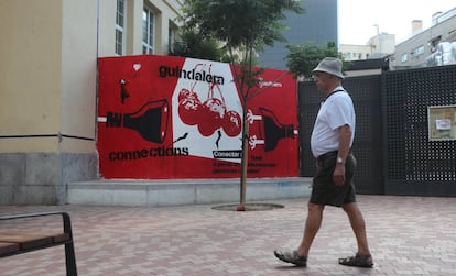 Un hombre pasea frente a un mural del espacio vecinal 'La Gasolinera', en Madrid.