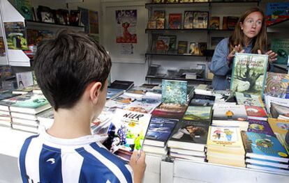 Un niño consulta un libro en la feria del Libro de Bilbao, el pasado junio.