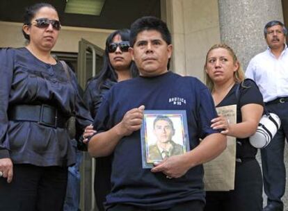 Rodrigo Cevallos, rodeado de familiares, porta un retrato de su hijo en la puerta del juzgado.