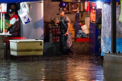 Vendedores de comida atrapados en sus puestos ante las intensas lluvias, en Ciudad de México, el pasado miércoles.