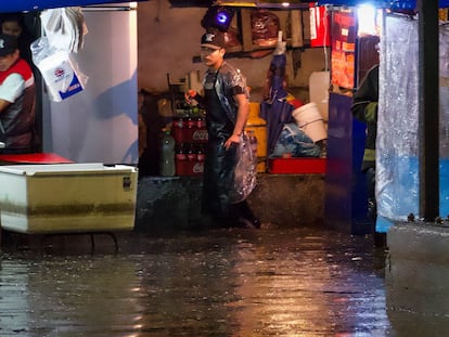 Vendedores de comida atrapados en sus puestos ante las intensas lluvias, en Ciudad de México, el pasado miércoles.