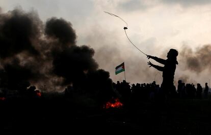 Un manifestante palestino utiliza una honda para arrojar piedras hacia las tropas israelíes durante los enfrentamientos, cerca de la frontera con Israel, al este de la ciudad de Gaza.