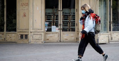 Una mujer pasea por París por delante de un restaurante cerrado.