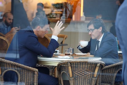 El presidente del Gobierno, Pedro Sánchez (izquierda), y el líder del PSC, Salvador Illa, charlan en una cafetería cercana a la sede de los socialistas catalanes en Barcelona.