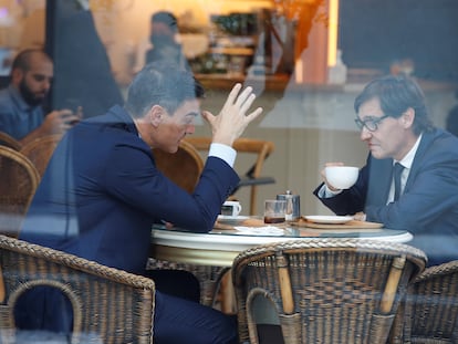 El presidente del Gobierno, Pedro Sánchez (izquierda), y el líder del PSC, Salvador Illa, charlan en una cafetería cercana a la sede de los socialistas catalanes en Barcelona.