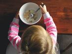 Una niña come un bol de cereales. 