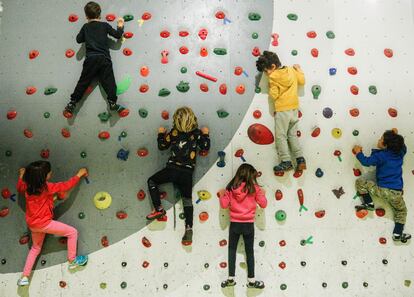 Varios niños hacen ejercicios de travesía el martes por la tarde en el rocódromo Urban Monkey de Villalba.