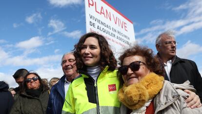 La presidenta de la Comunidad de Madrid, Isabel Díaz Ayuso (i), posa con una mujer durante su visita a las obras del Plan Vive en San Sebastián de los Reyes, el 9 de marzo de 2023.