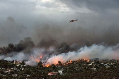 A Grècia, la majoria de les víctimes han quedat atrapades al sector de la localitat balneària de Mati, a uns 40 quilòmetres al nord-est d'Atenes. A la imatge, un helicòpter sobrevola el poble de Rafina, envoltat per les flames.