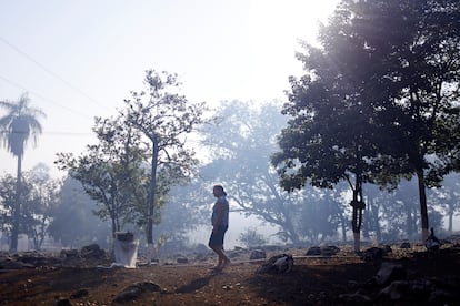 A woman walks through the smoke of the fires, in Corumba (State of Matto Grosso do Sul), on June 12.