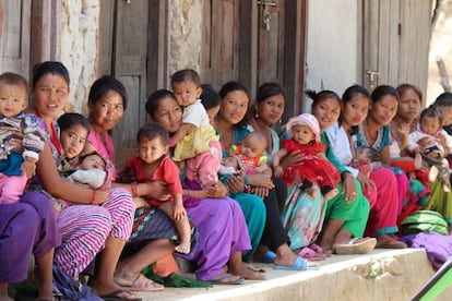 Un grupo de mujeres hace cola con sus hijos para que les atiendan en un puesto de salud establecido en una carpa. 