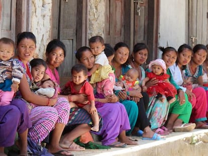 Un grupo de mujeres hace cola con sus hijos para que les atiendan en un puesto de salud establecido en una carpa. 