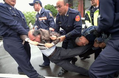 Policías detienen a unos manifestantes durante una protesta frente al Parlamento en Taipéi (Taiwan).