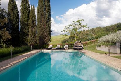 La piscina está situada en la parte trasera de la finca, 
junto a su frondoso jardín. Las tumbonas son de ratán, 
y la cama redonda con capota, de Kettal.