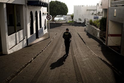 Un agente de la Guardia Civil camina por una calle cubierta por cenizas volcánicas en Puerto de Naos, lugar evacuado y desalojado, en la isla de La Palma.