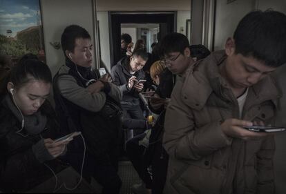 Algunos pasajeros chinos viajan en el vagón sin asientos del tren entre Pekín y Shijiazhuang.