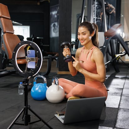 Active Asia woman sportswear conversation talking to camera and showing accessory for weight training to customer on internet