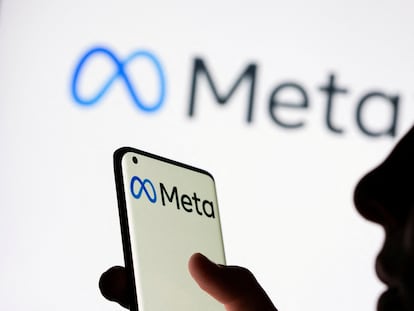FILE PHOTO: Woman holds smartphone with Meta logo in front of a displayed Facebook's new rebrand logo Meta in this illustration picture taken October 28, 2021. REUTERS/Dado Ruvic/Illustration/File Photo