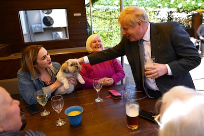 Johnson acaricia al perro de la cliente de un bar, en Wolverhampton el pasado 19 de abril.