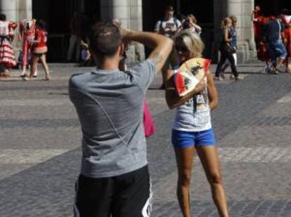 Una visitante de la madrileña Plaza Mayor posa para una foto luciendo un abanico con motivos taurinos. EFE/Archivo