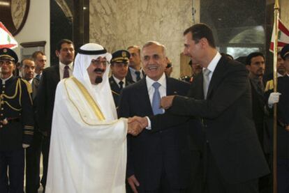 El rey Abdalá, a la izquierda, y Bashar el Assad estrechan sus manos ante la mirada de Michel Suleimán.