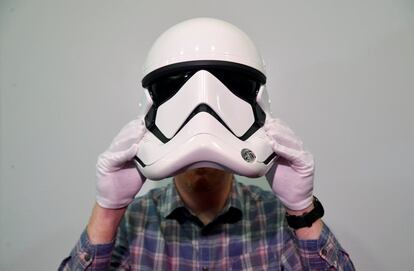 Un empleado posa con un casco de Stormtrooper utilizado en Star Wars Episodio VIII, Los últimos Jedi. 