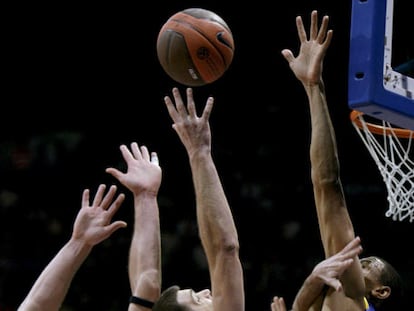 Reyes intenta encestar entre Javtokas y McCarty.