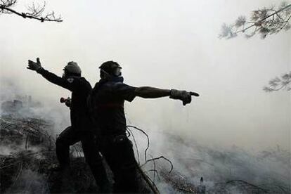 Dos bomberos luchan contra el fuego en el municipio de Pobra do Caramiñal.