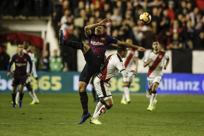 Luis Suárez intenta rematar de cabeza, ante la oposición de Raúl deTomás.