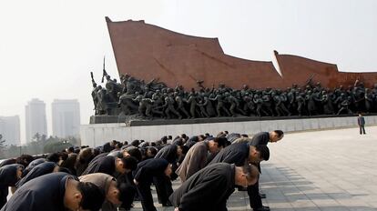 Norcoreanos en el Gran Monumento de la Montaña Mansu, que contiene el homenaje a la revolución socialista (en la imagen, al fondo) y las gigantescas estatuas de 22 metros de Kim Il-sung y su hijo, Kim Jong-il (fuera de la fotografía, a la derecha), hacia las que dirigen sus reverencias los visitantes. El primero dirigió el país desde su fundación, en 1948, hasta su muerte, en 1994. Su hijo heredó el poder, que ostentó hasta 2011, cuando, al fallecer, el actual dictador asumió las riendas.