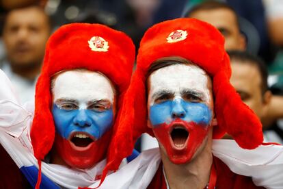 Dos seguidores con las caras pintadas con la bandera de Rusia esperan el inicio de la ceremonia.