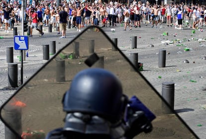 Un policía francés se protege detrás de su escudo durante la batalla campal que han montado los radicales ingleses.