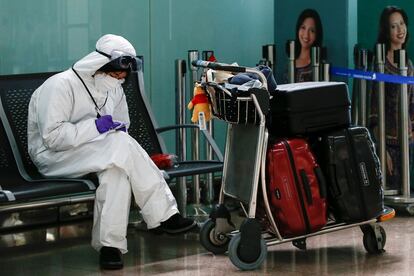 Una pasajera consulta su dispositivo móvil en la terminal T1 del aeropuerto de Barcelona-El Prat, que concentra todas las operaciones tras el cierre de la T2.