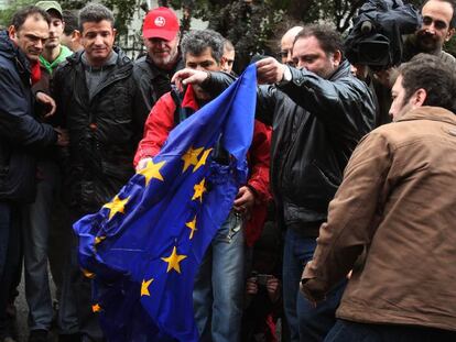 Un grupo de manifestantes quema una bandera de la UE durante la protesta de ayer en Atenas.