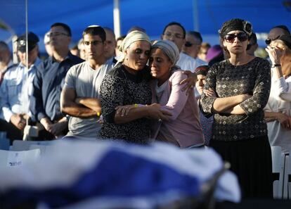 Bat-Galim Shaer (d) e Iris Yifrah (c), madres de dos de los tres jóvenes israelíes secuestrados y asesinados asisten al funeral colectivo que se lleva a cabo en Modi'in (Israel).