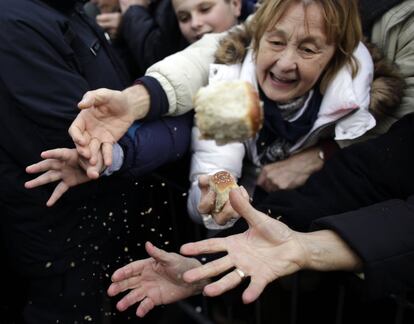 Cristianos serbios ortodoxos reciben un trozo de pan durante la celebración de las festividades del Día de la Navidad ortodoxa, en Belgrado (Serbia).