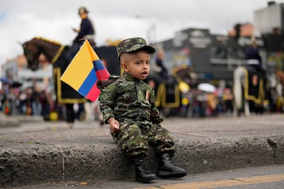 Un niño caracterizado con un disfraz de militar asiste al desfile militar.