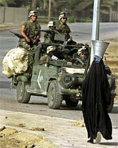 Una mujer de Nasiriya pasa ante un grupo de <i>marines.</i>