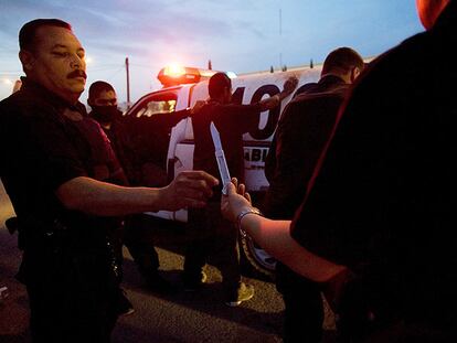 Un agente municipal de Ciudad Juárez requisa una navaja que llevaba un detenido.