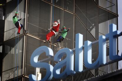 Papa Noel y dos elfos bajan haciendo rapel en el hospital Vall D'Hebron de Barcelona, para dejar los regalos a los niños hospitalizados, este sábado.