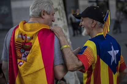 Un hombre con la bandera de Espa&ntilde;a y otro con una estelada, el 12 de octubre en Barcelona.