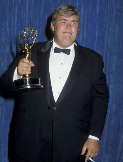 John Candy, cigarro en mano, posa ante la prensa con el Emmy que ganó en 1983.