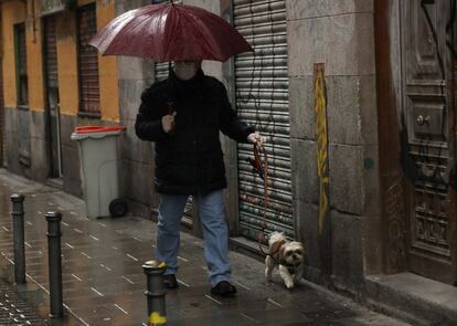 Un hombre pasea a su perro en el madrileño barrio de Malasaña, que se presentaba prácticamente vacío este sábado.