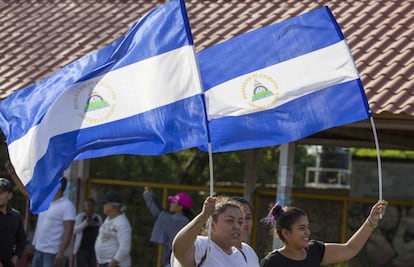 Dos jóvenes levantan la bandera de Nicaragua durante la manifestación contra el Gobierno del presidente Daniel Ortega en Managua (Nicaragua).