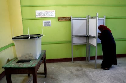 Uma mulher prepara sua cédula em uma cabine antes de votar em um centro eleitoral do Cairo.